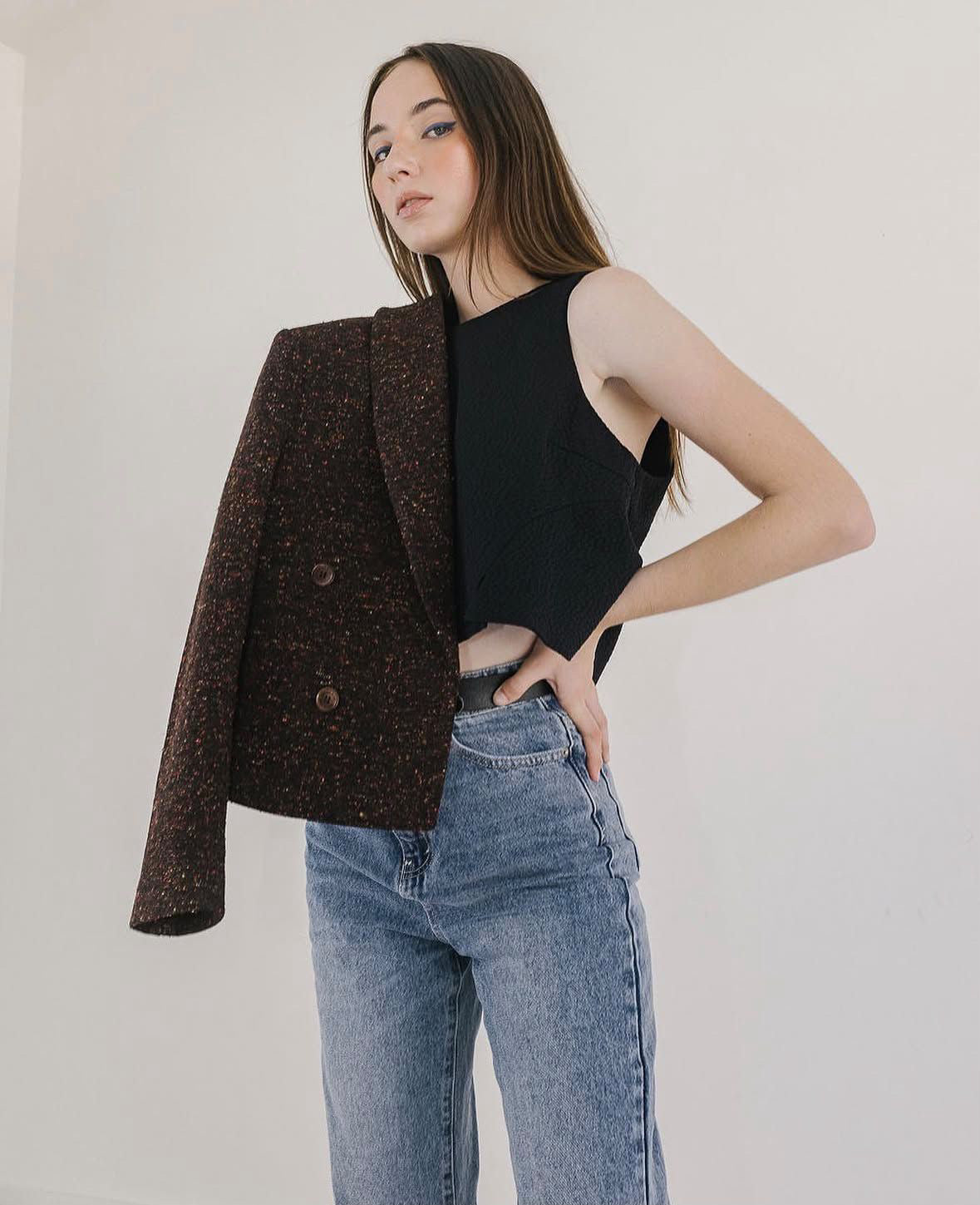 Woman wearing a brown tweed blazer over a black top